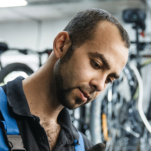 Bicycle repair in workshop, man installs star cassette. Mechanic in uniform fix problems with cycle, professional bike repairing service